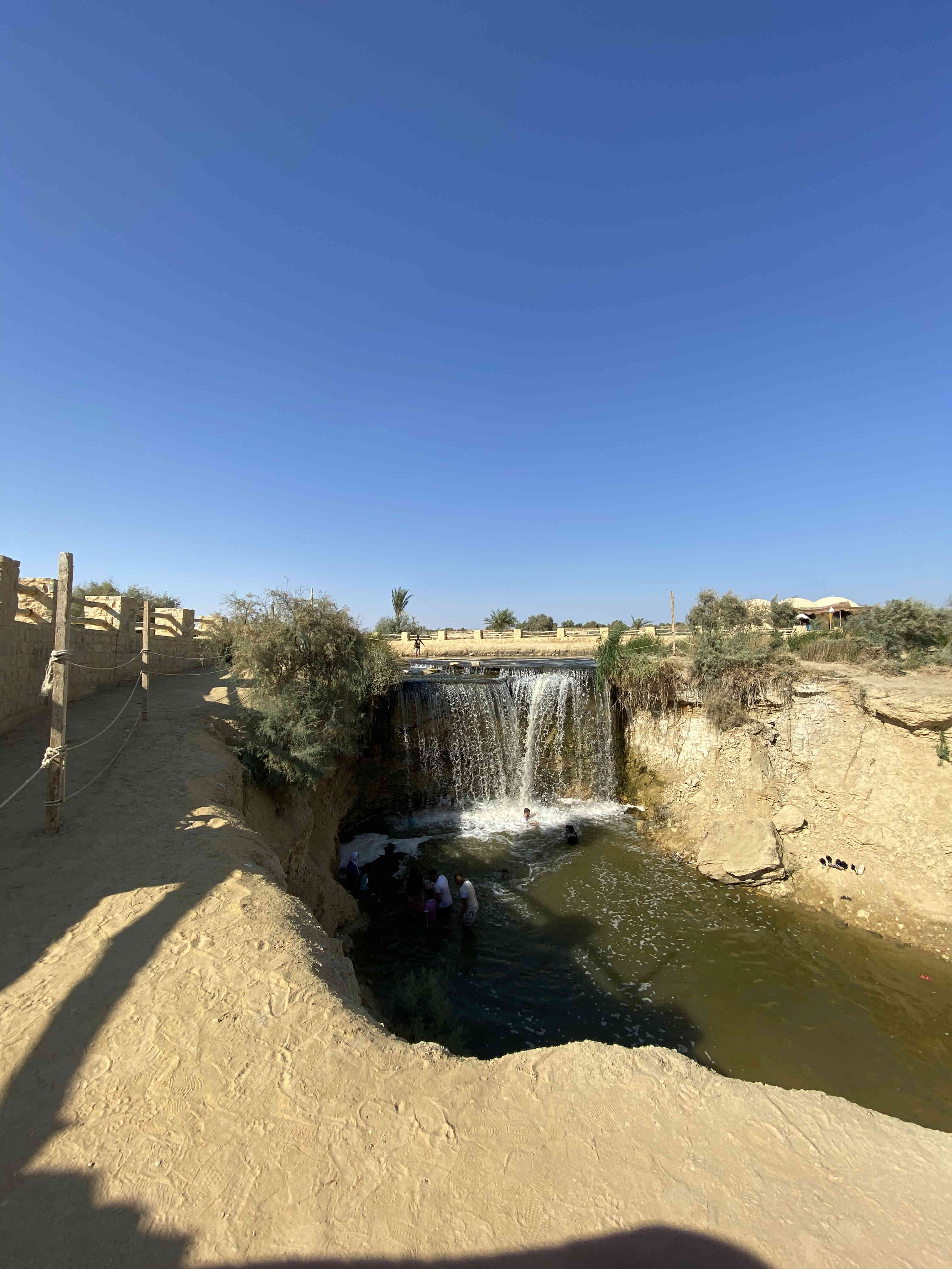 Une petite cascade artificielle se jetant dans un étang tranquille dans une oasis du désert du Fayoum