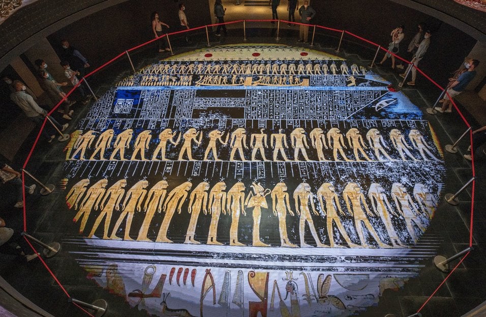 Une grande projection circulaire au sol représentant de l'art funéraire et des hiéroglyphes de l'Égypte antique.