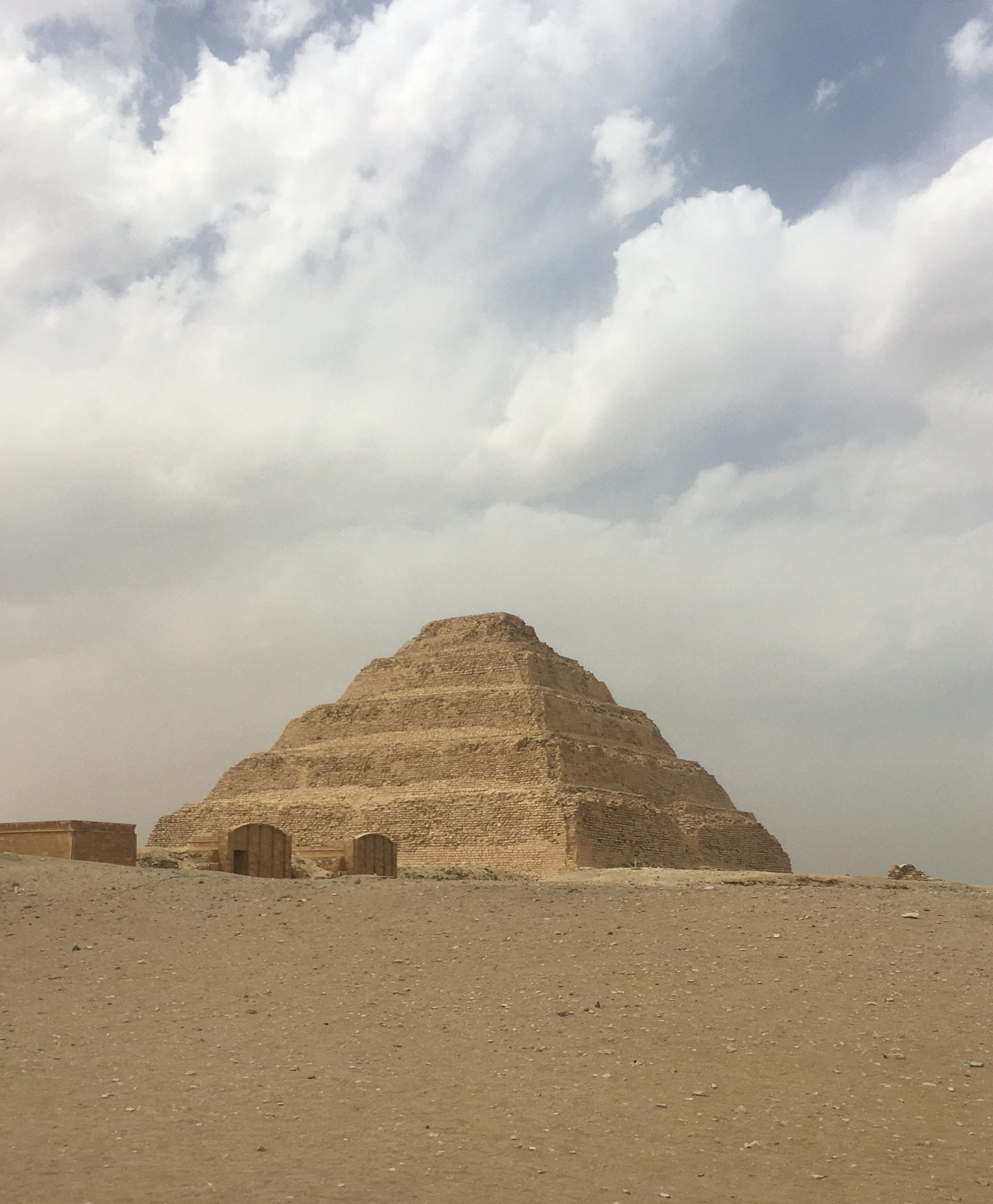 La structure à six degrés de la Pyramide de Djoser à Saqqara, le plus ancien monument en pierre du monde, sur le plateau désertique sous un ciel nuageux