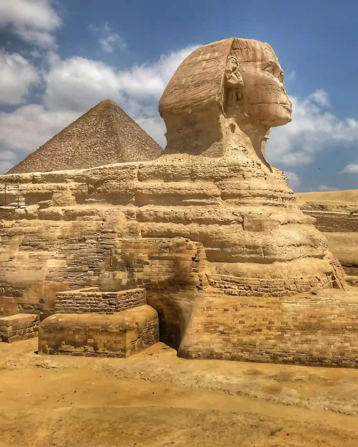 The Great Sphinx of Giza stands in profile before the Giza Pyramids