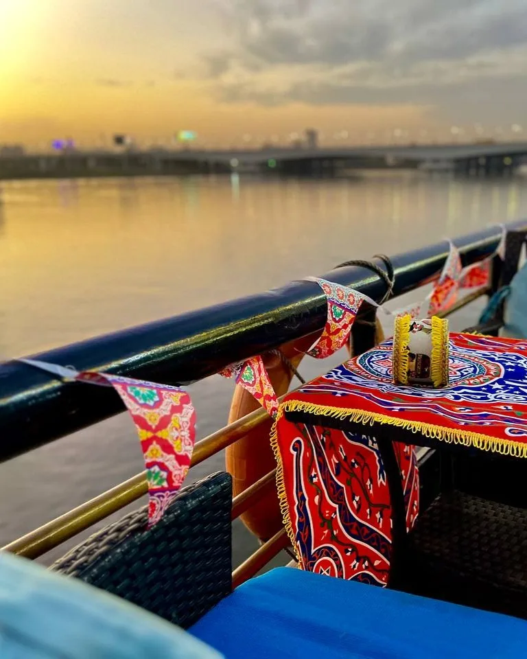 Pont décoré d'un bateau sur le Nil au coucher du soleil