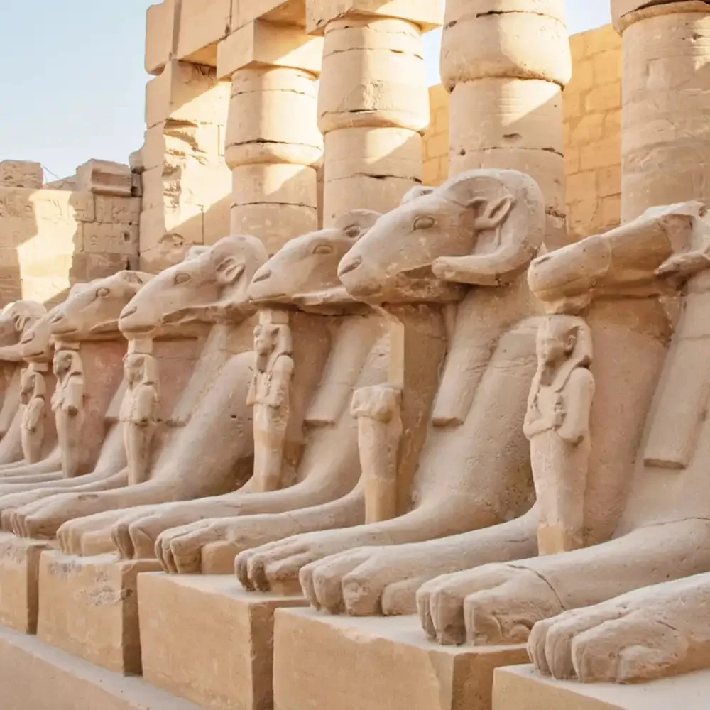 Une rangée d'anciens sphinx à tête de bélier gardant le temple de Karnak