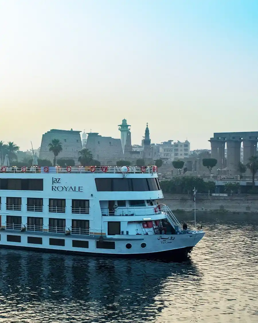 Un bateau de croisière sur le Nil passe devant les ruines antiques de la rive est de Louxor