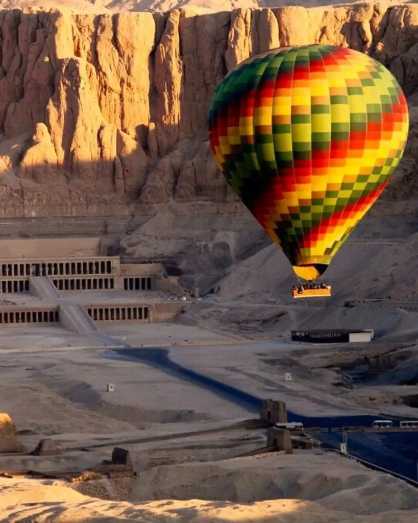 Une montgolfière dérive au-dessus du temple funéraire en terrasses d'Hatchepsout