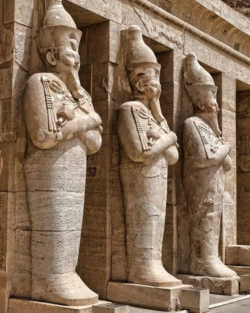 Des statues d'Osiride représentant la reine Hatshepsout bordent le portique ensoleillé de son temple mortuaire à Deir el-Bahari