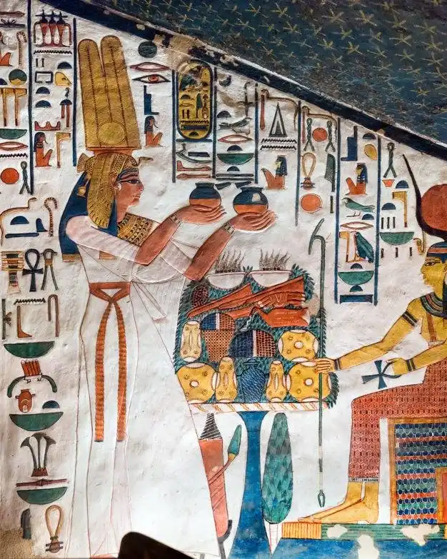 Une peinture murale à l'intérieur du tombeau de Néfertari représente la reine Néfertari offrant des vases à la déesse Hathor