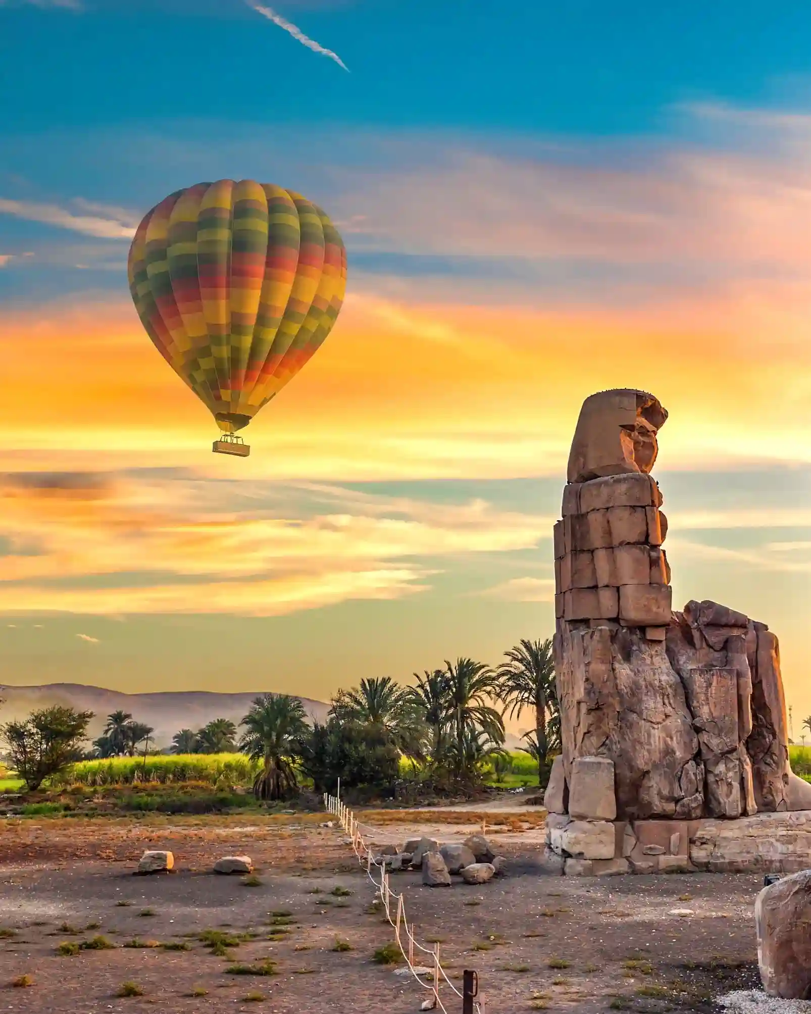Montgolfière à côté de l'un des colosses de pierre géants et antiques de Memnon