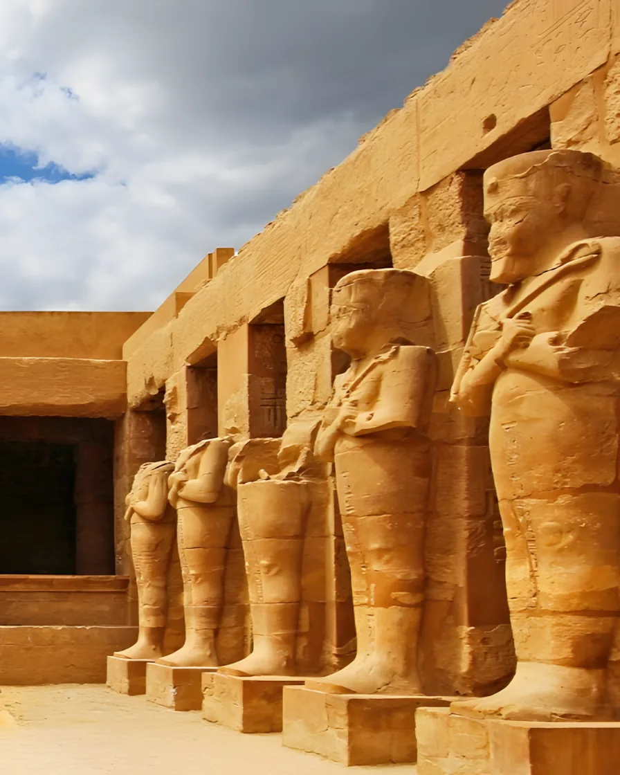Une rangée de statues osirides monumentales se dressent le long de la cour du temple de Ramsès III