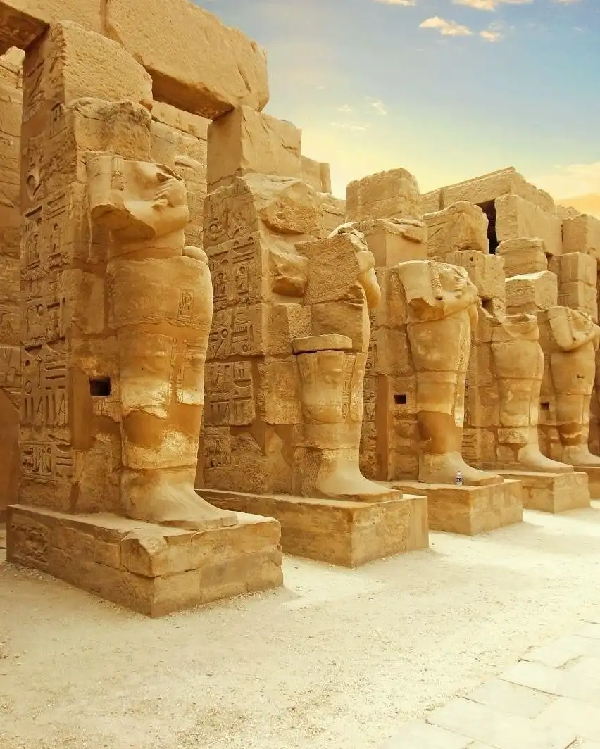 Une rangée de statues de pierre colossales et antiques de pharaons sous la forme d'Osiris au temple de Karnak